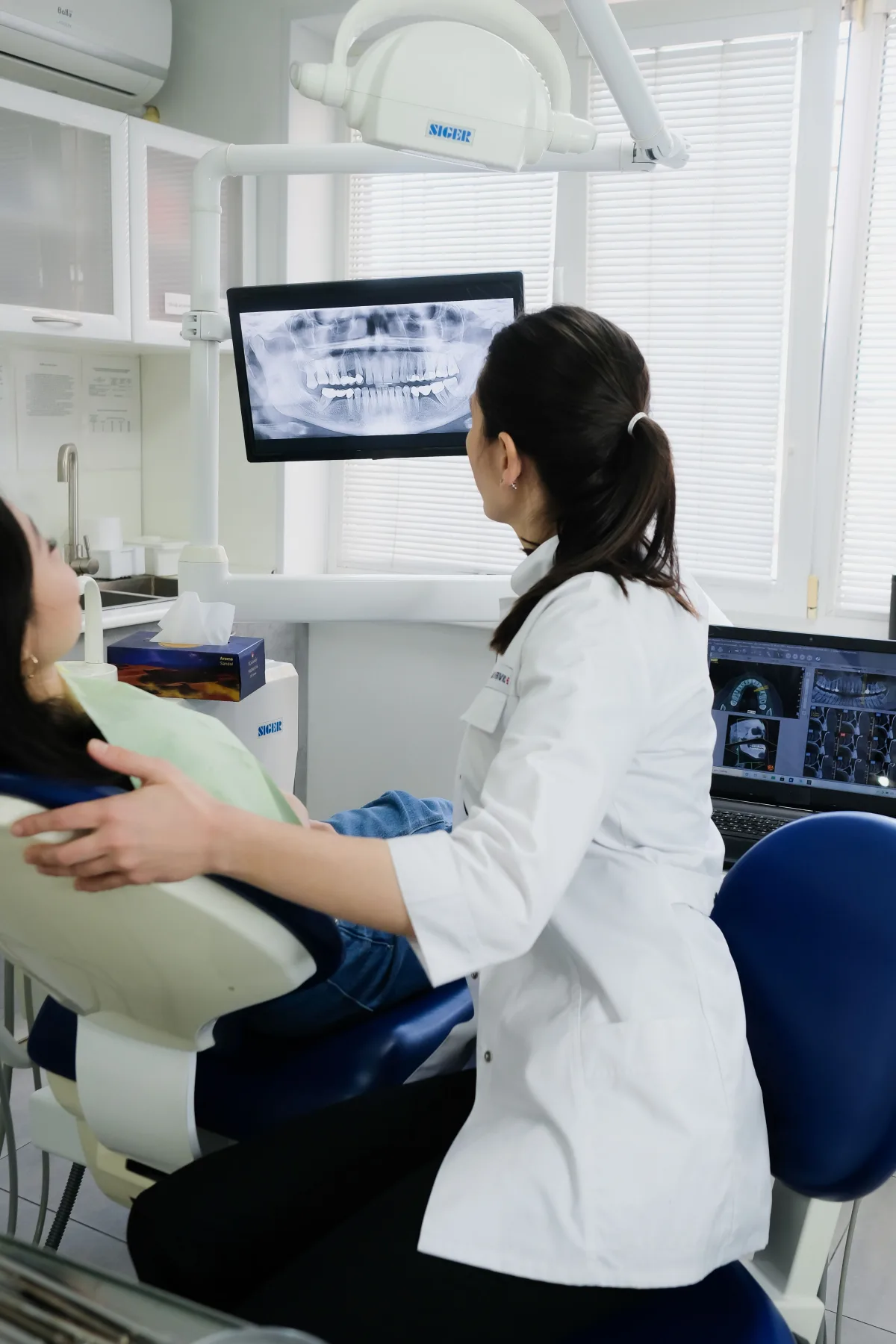 A dentist reviewing a dental X-ray with a patient