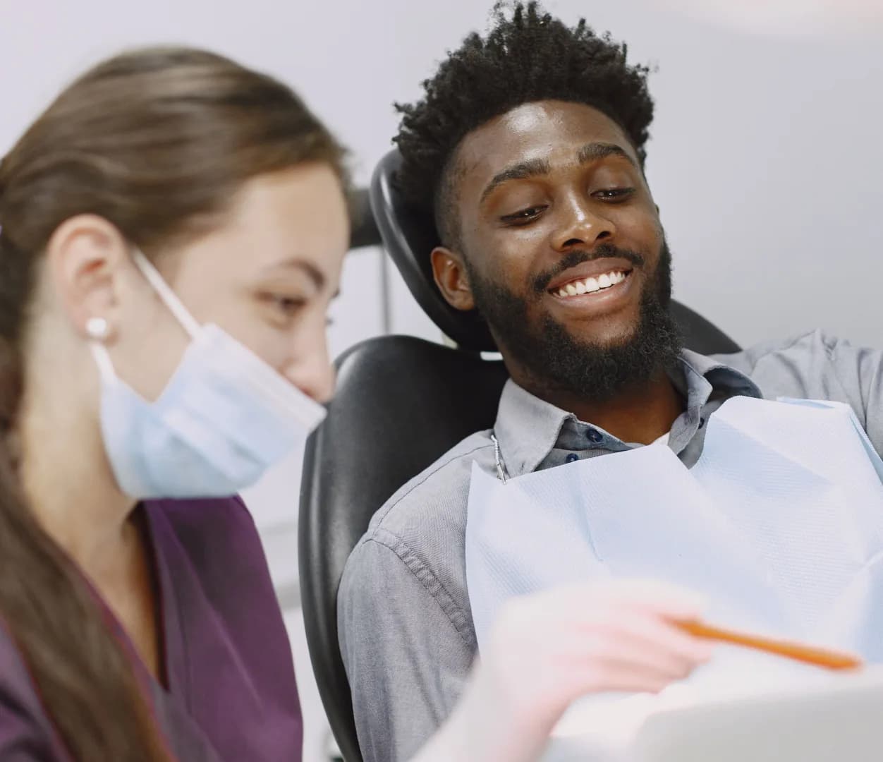 A dental professional speaking with a patient during an appointment
