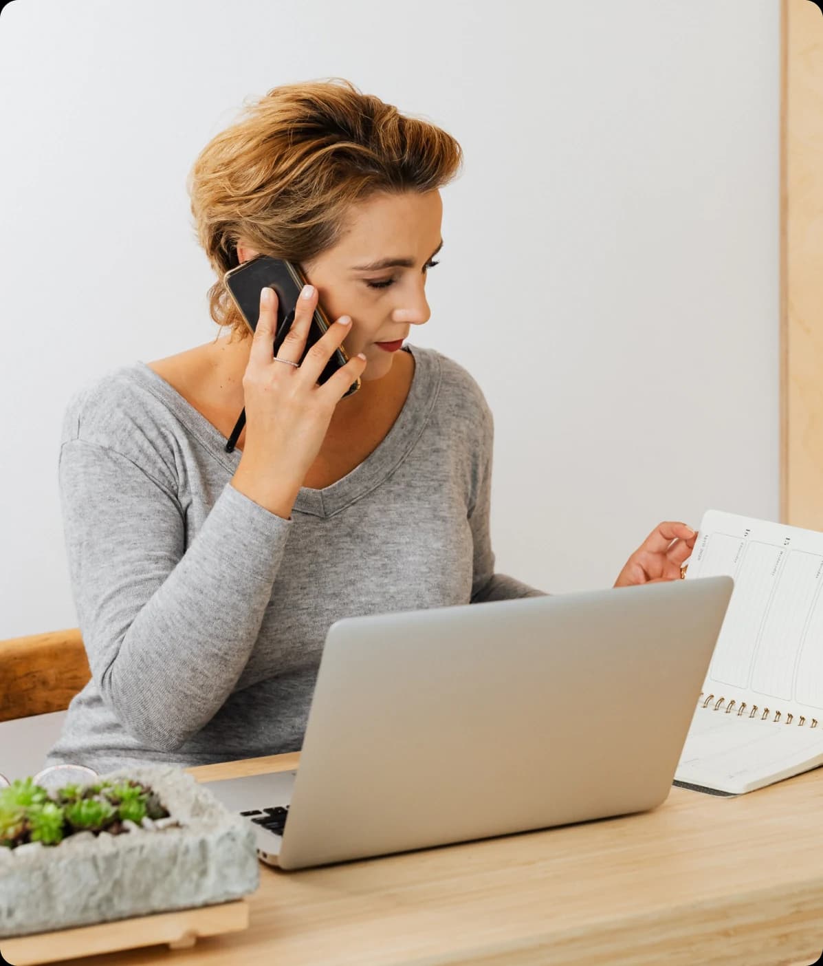Clinic team member speaking on the phone beside a laptop